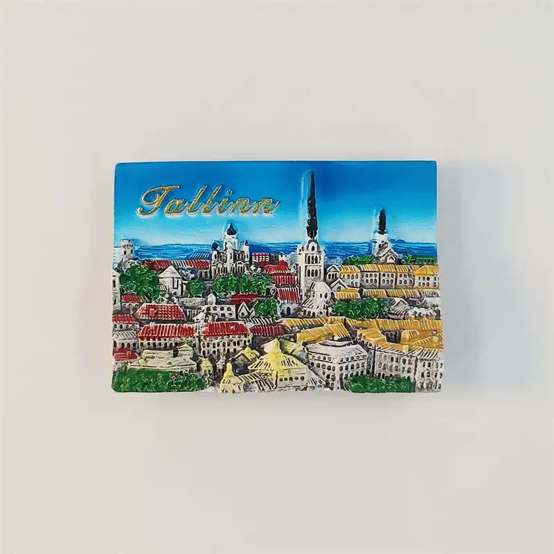 estonia-tallinn-old-town-skyline-fridge-magnet-front Rectangular Tallinn Old Town fridge magnet with slender spires, red and yellow rooftops, green trees and gold Tallinn lettering against a blue sky.