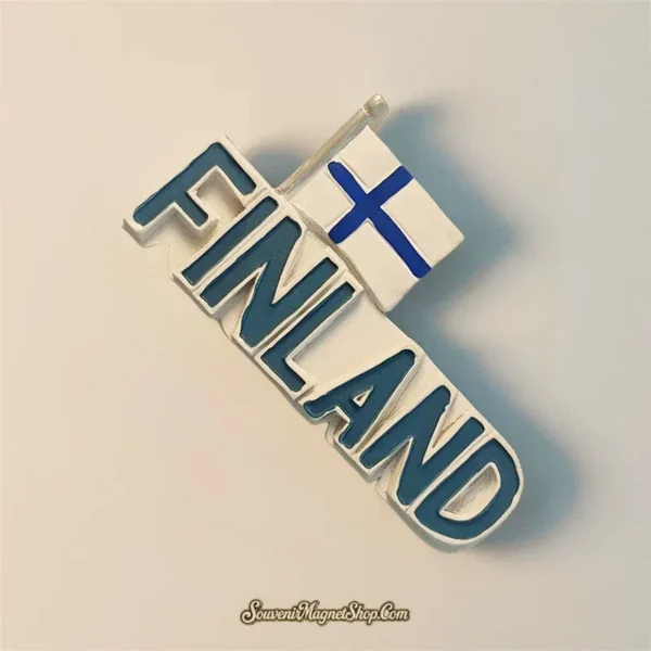 Angled view of the Finland wordmark fridge magnet showing raised blue letters and the white flag with a blue Nordic cross.