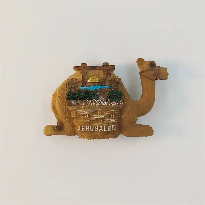 jerusalem-camel-cityscape-fridge-magnet-front Jerusalem camel-shaped fridge magnet with stone buildings, greenery, a blue accent, golden dome, and raised JERUSALEM lettering.