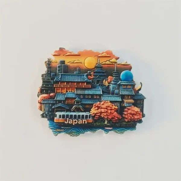 Kyoto cityscape fridge magnet with blue-green tiled roofs, pagodas, an orange sunset, trees and a train marked Japan, front view