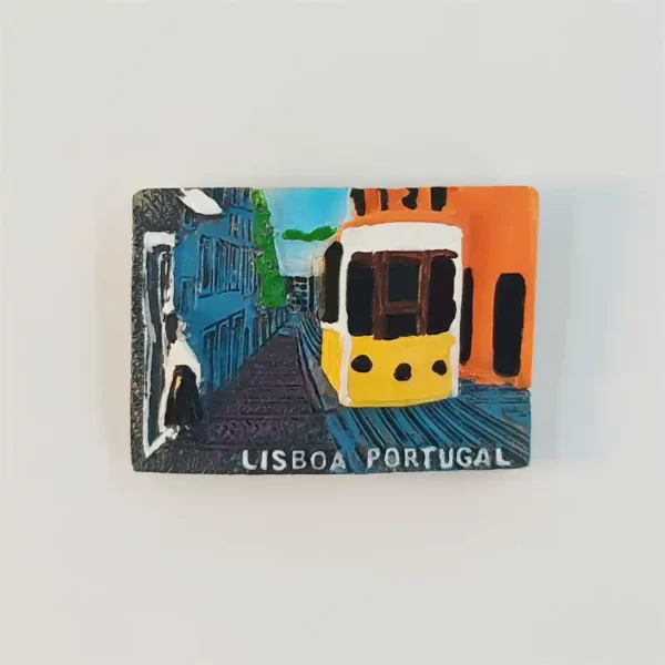 Lisbon street scene fridge magnet with a yellow-and-white tram between blue and orange buildings and LISBOA PORTUGAL lettering.