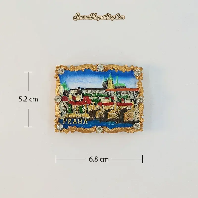 Charles Bridge B variant fridge magnet with bridge arches over blue water, red rooftops and a distant castle skyline; 6.8 cm wide and 5.2 cm high.