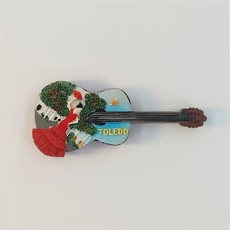 toledo-guitar-flamenco-dancer-fridge-magnet-front Toledo guitar-shaped fridge magnet with a red-dressed dancer holding a fan, white buildings, green trees and yellow TOLEDO lettering.